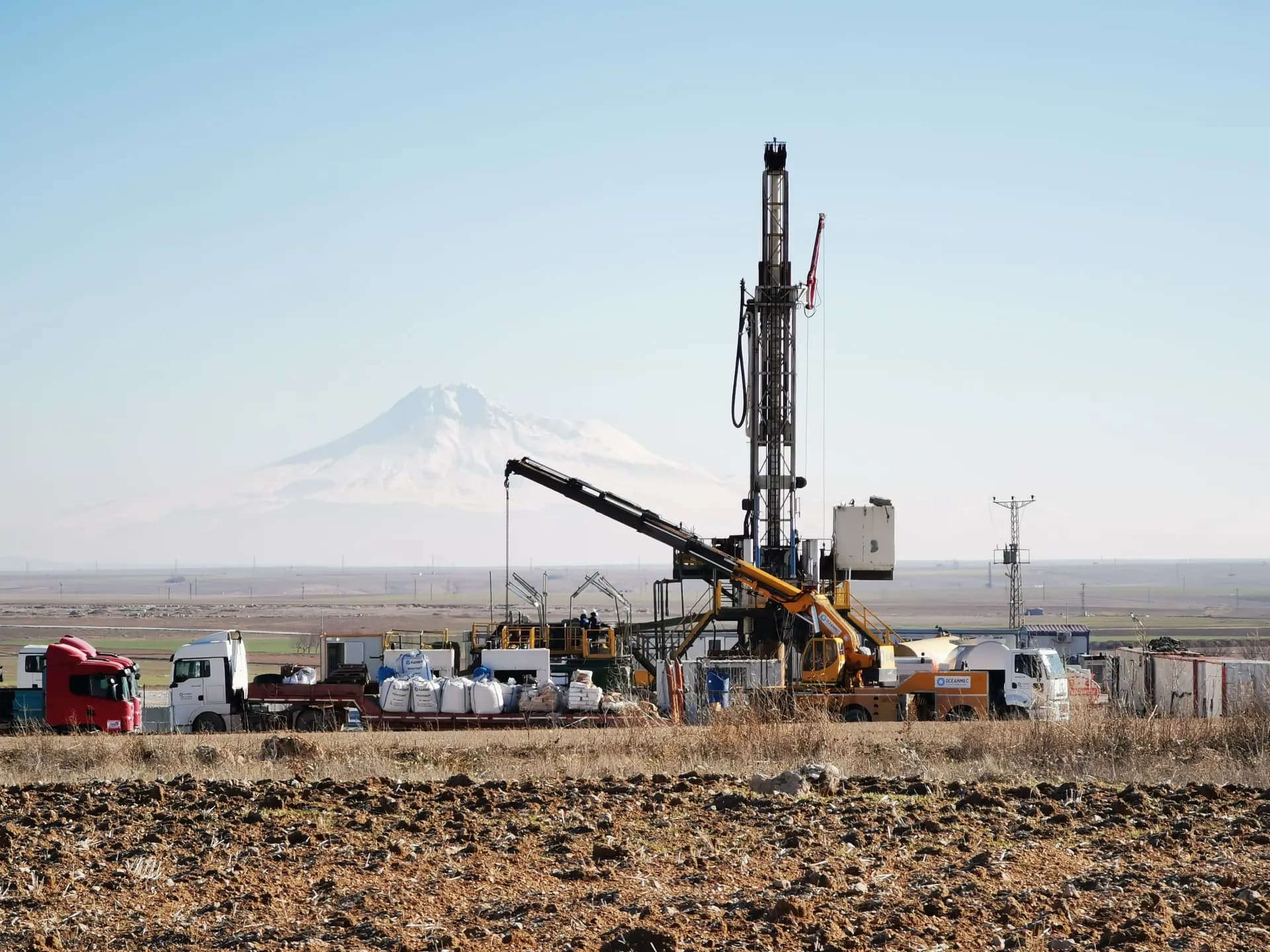 Rig operating with a snow-capped mountain backdrop