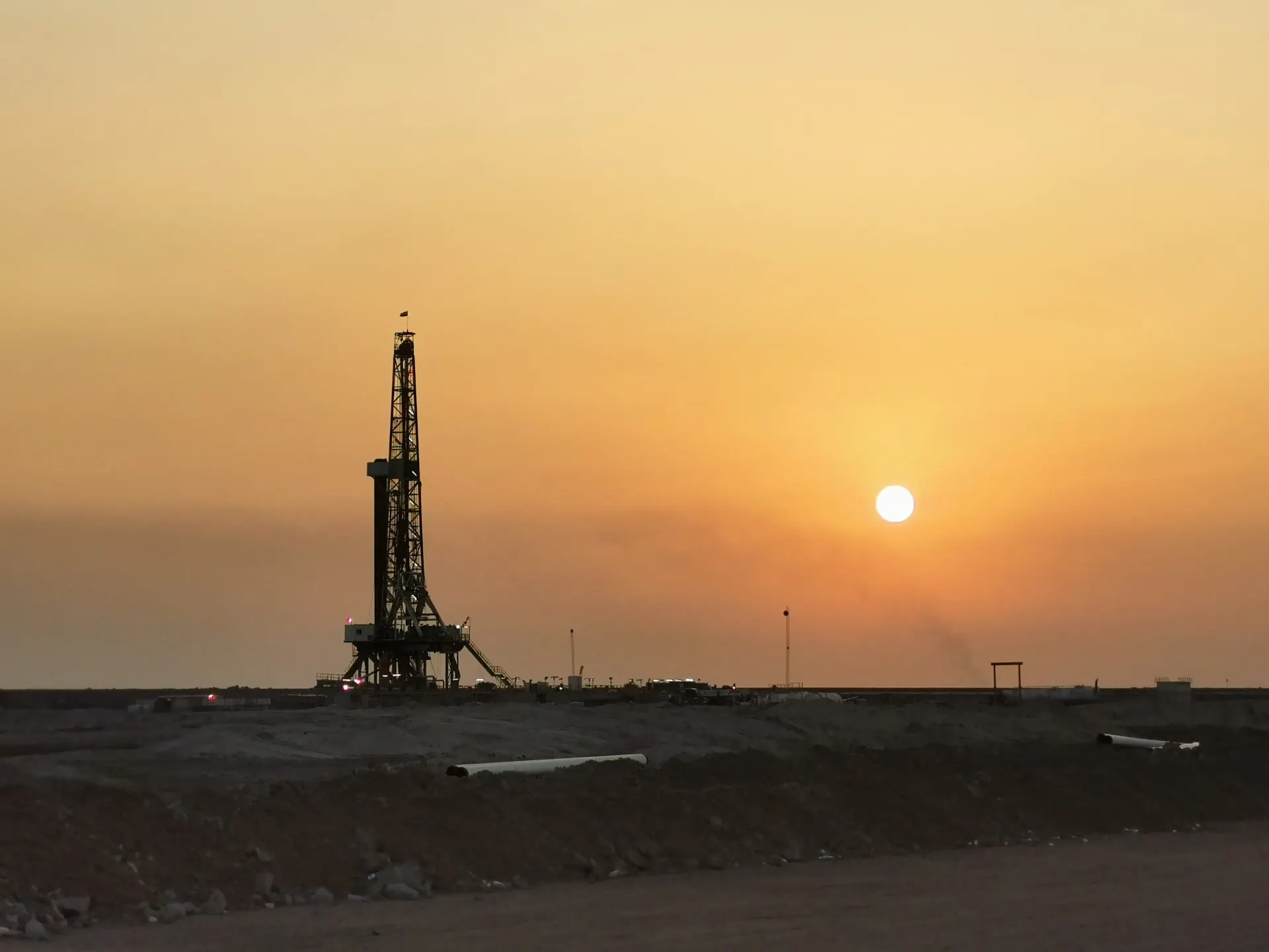 Drilling rig silhouetted at sunset