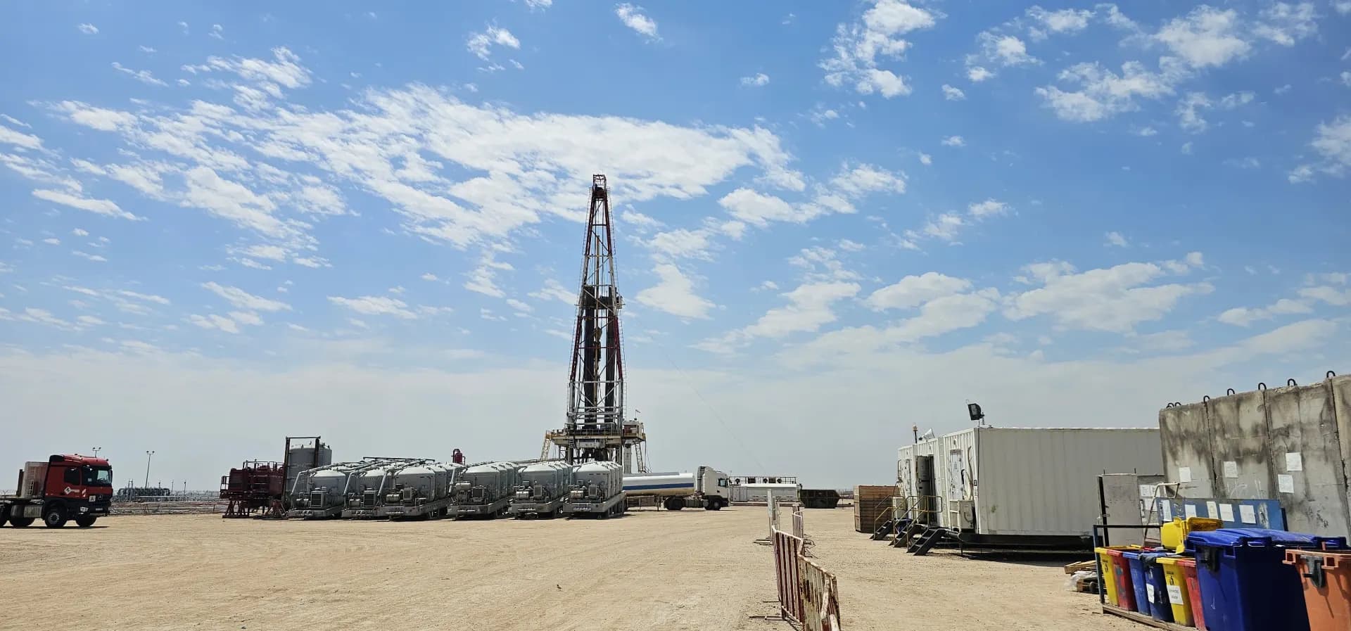 Rig site equipment yard under a partly clouded sky